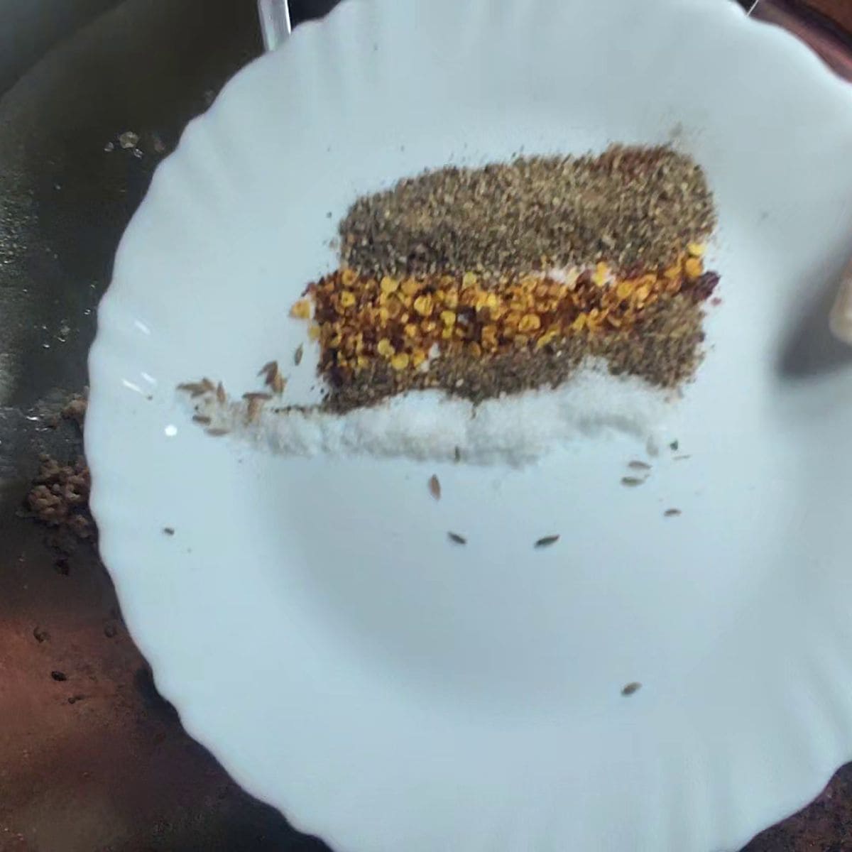 a white plate showing the spices that are on the plate