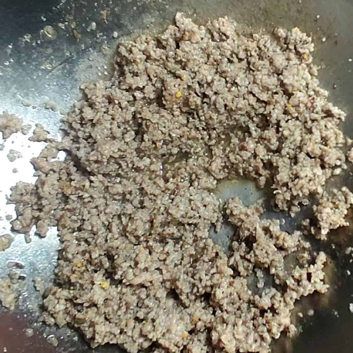process of making beef mince a silver wok having beef mince 