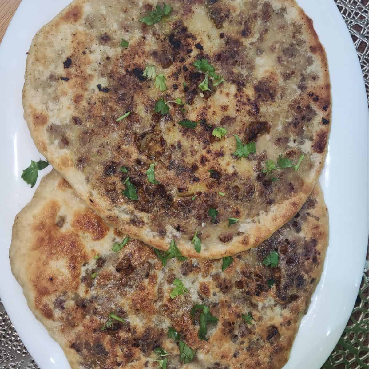 Freshly made keema naan served with sprinkle of fresh coriander leave on top 