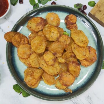 aloo pakora shown in plate with chutney on side