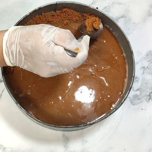 Decorate the cheesecake with crushed Lotus biscuits.