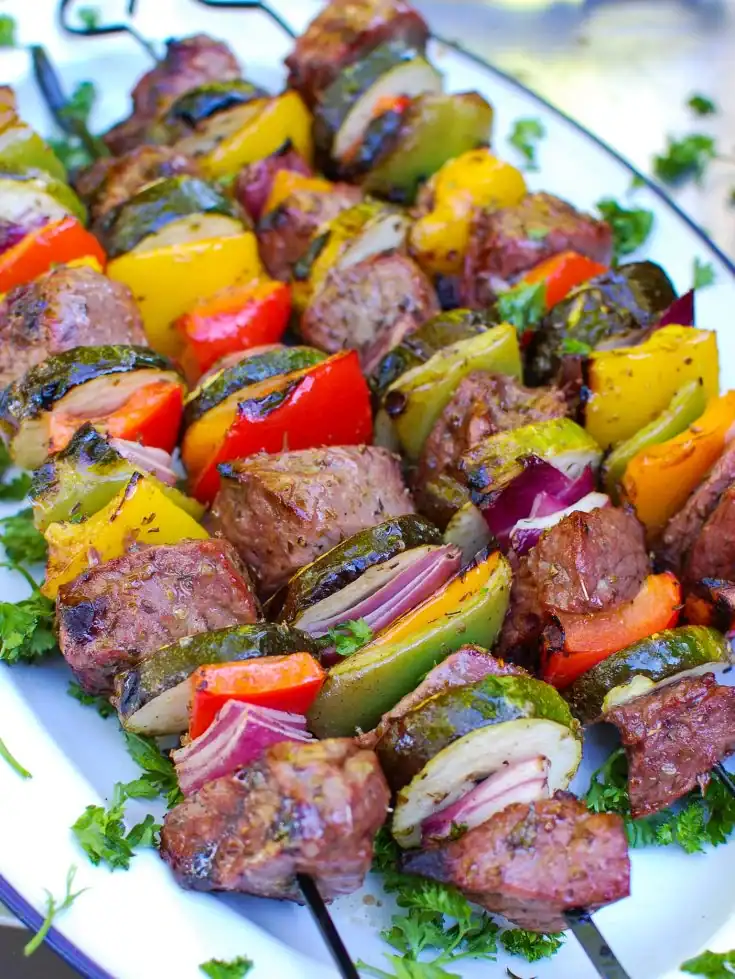 Mediterranean beef kabobs sirloin cubes peppers onions zucchini olive oil garlic herbs colorful grilled summer BBQ
