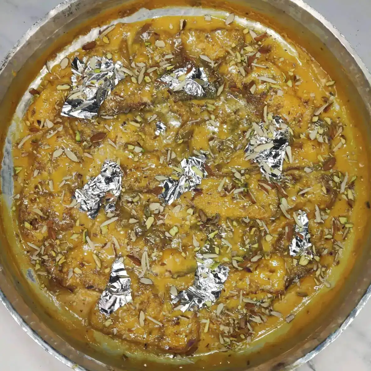 Before serving, garnish the Shahi tukra with almonds and pistachios.