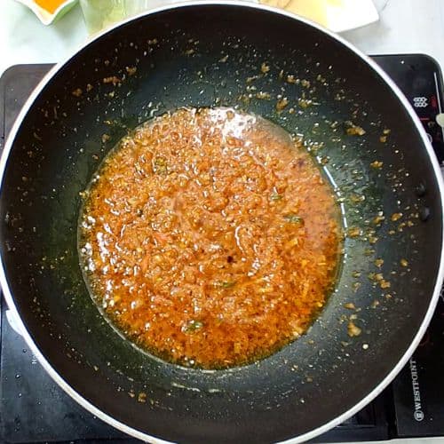 Dal mash cooking in a wok with golden-brown lentil paste and caramelized edges on stovetop.