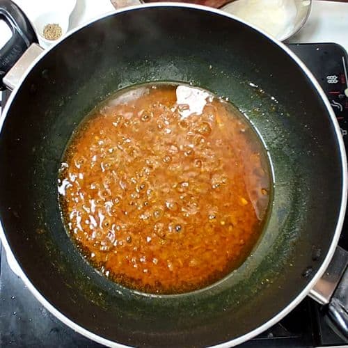 Daal Mash simmering in a dark cooking pot with bubbling reddish-brown lentil curry.