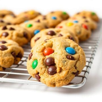 Soft and chewy M&M chocolate chip cookies arranged on a cooling rack with colorful candies.