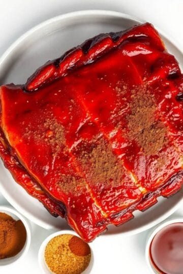 Delicious smoked baby back ribs glazed with rich barbecue sauce, served with spices and dipping sauc.