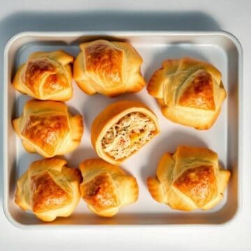 Delicious homemade crescent rolls filled with seasoned chicken and cheese, baked to golden perfectio.