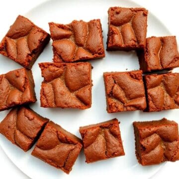 Delicious brownies and blondies cut into squares on a white plate.