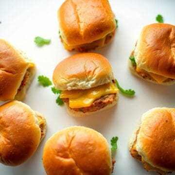 Mini chicken sliders with cheese and fresh greens.