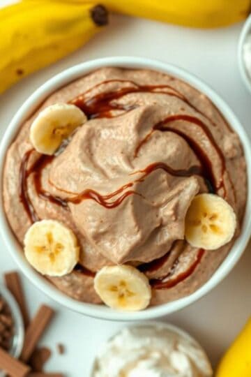 Delicious chocolate banana pudding fluff topped with banana slices and chocolate drizzle.