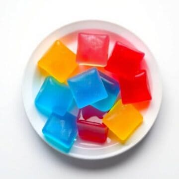 Colorful Kool-Aid gummy candies on a white plate.