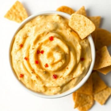 Queso cheese dip served with crispy tortilla chips, perfect for snacking or parties. Rich, cheesy, a.