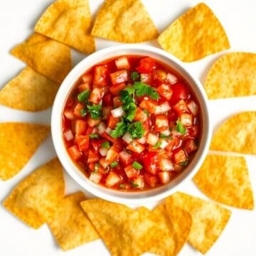 Delicious homemade salsa served with crispy tortilla chips, perfect for snacking or entertaining gue.