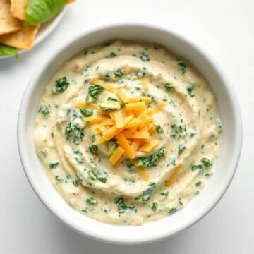Delicious spinach and artichoke dip topped with shredded cheese, perfect for parties and appetizers.