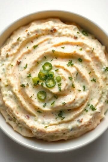 Delicious dill pickle dip garnished with chopped green onions.