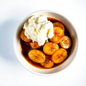 Bananas Foster with ice cream in a bowl, caramelized bananas and sauce.