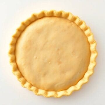 Delicious homemade pie crust ready for baking, showcasing a golden, flaky texture. Ideal for sweet a.