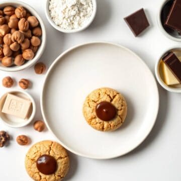 Delicious Baci di Dama cookies with chocolate centers on a white plate. Perfect for Italian dessert.
