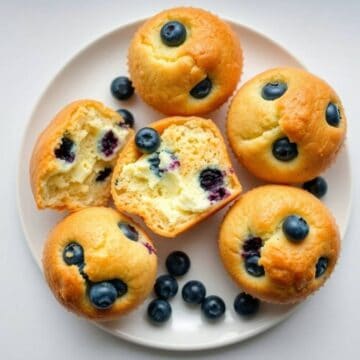 Delicious blueberry cream cheese muffins topped with fresh blueberries, perfect for breakfast or sna.