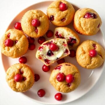 Delicious cranberry cream cheese muffins with fresh berries on top.