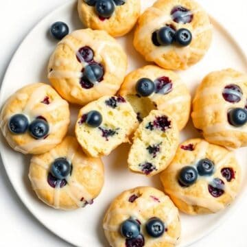 Fresh glazed blueberry butter swim biscuits with blueberries on top.