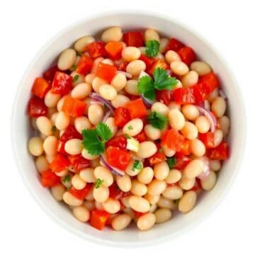 Healthy marinated white beans with fresh vegetables and herbs.
